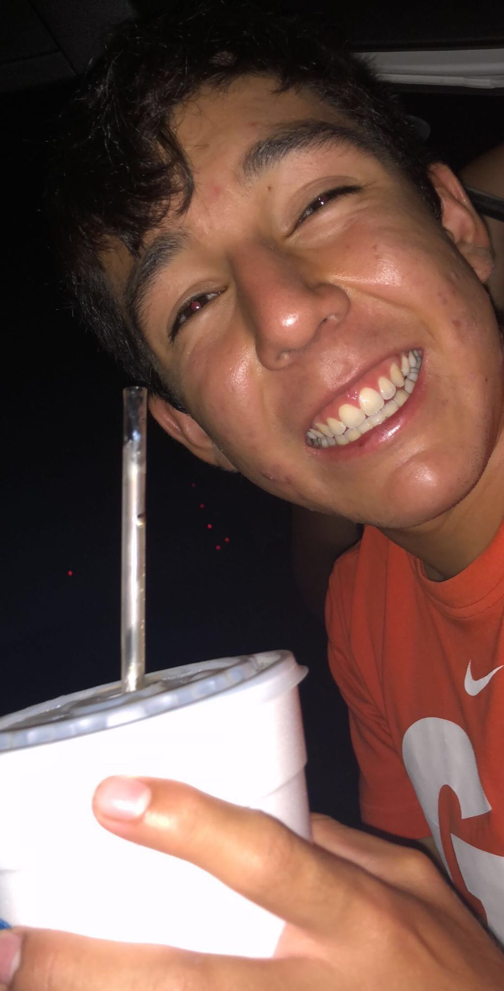 Armando Mascote smiles wide while holding a styrofoam cup